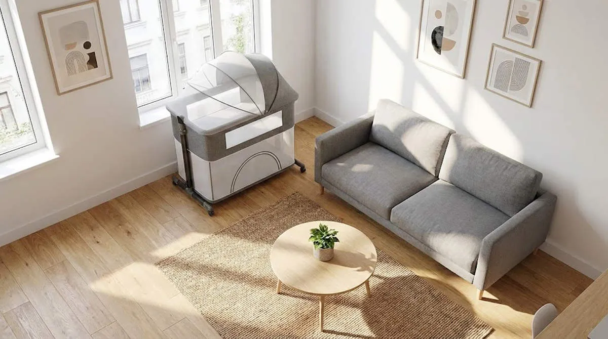 Modern grey Convertible Bassinet Playpen placed in a compact sunlit living room, illustrating space-saving design.