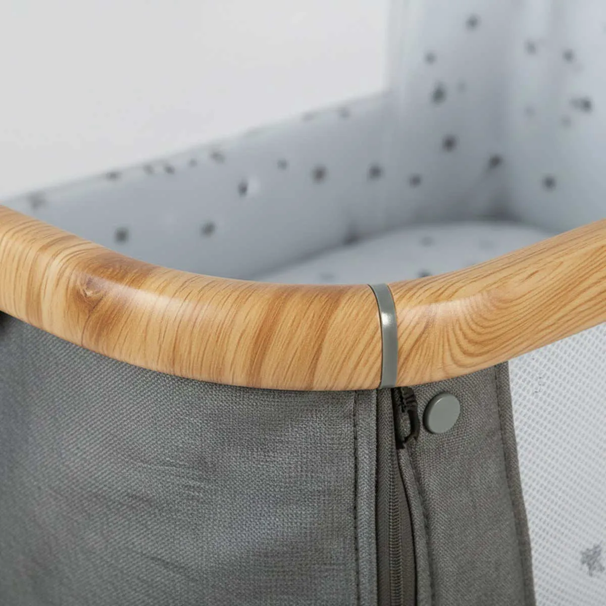 Close-up detail of Wood Grain Aluminum Crib texture showing realistic oak finish on metal frame.