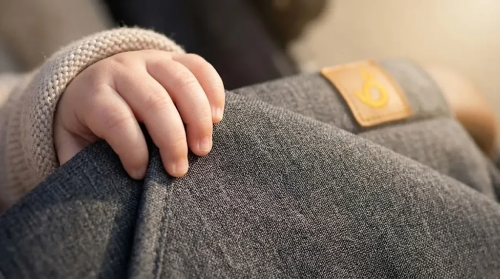 Close-up of a baby hand touching soft, skin-friendly REACH compliant baby products fabric to show non-toxic quality.