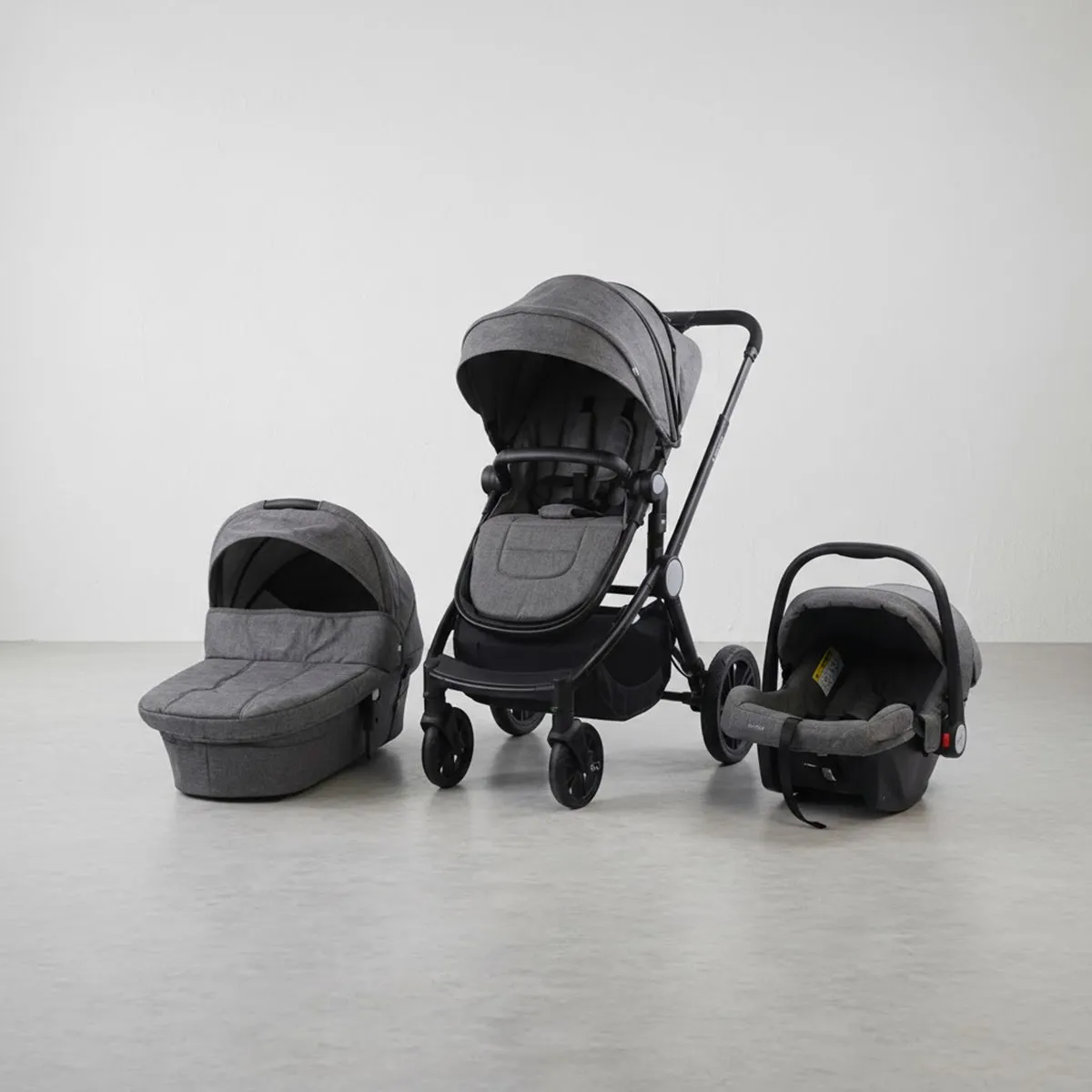 Wholesale Baby Accessories trend: Stylish grey stroller and car seat travel system bundle displayed on a concrete floor.